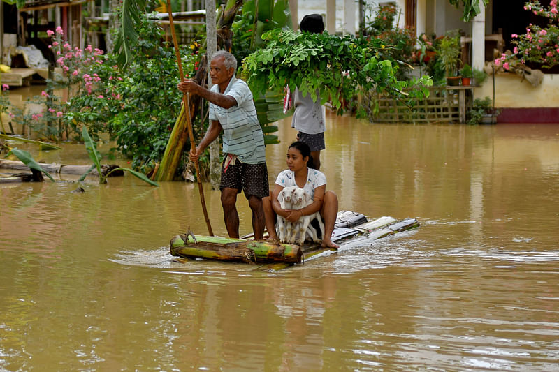 Flood-affected people use a makeshift raft to shift their lamb to a safer place following heavy rains at the Patiapam village in Nagaon district, in the northeastern state of Assam, India on 3 July 2024